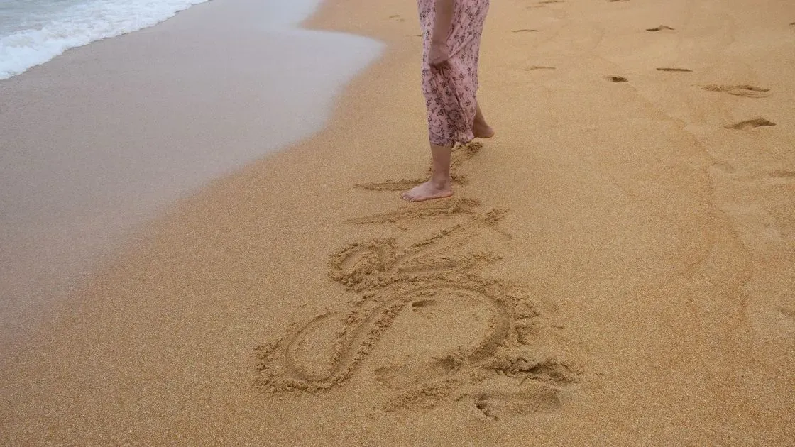 Kvinna promenerar på stranden