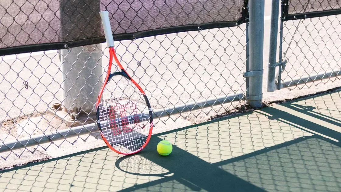 Spelare slår tennisboll på bana