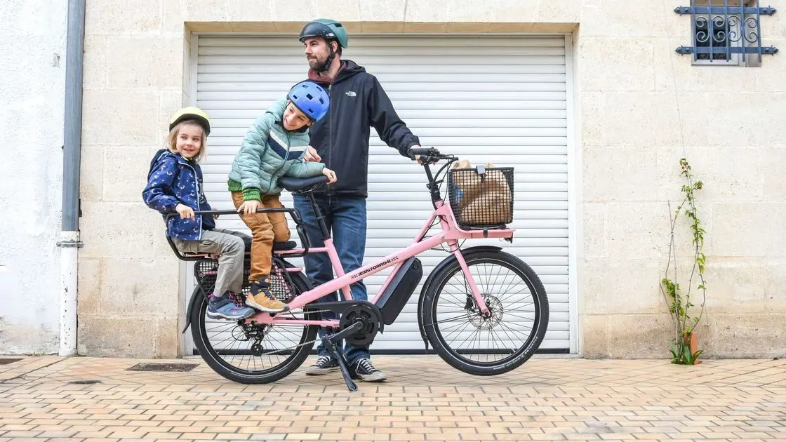 Person som cyklar lådcykel i stan