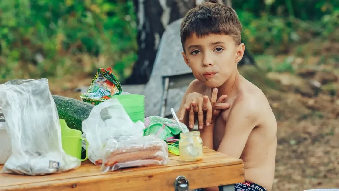 Barn som sitter vid ett picknickbord