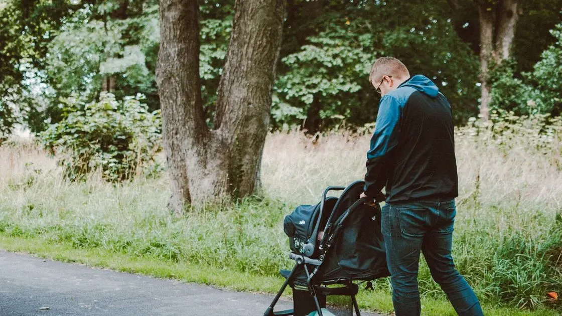 Förälder kör barnvagn i staden